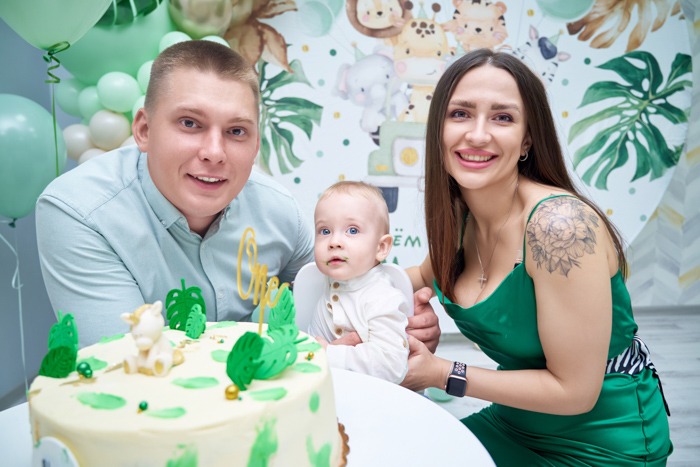 Семейный фотоснимок с именинным тортом в стиле Сафари от профессионального детского фотографа